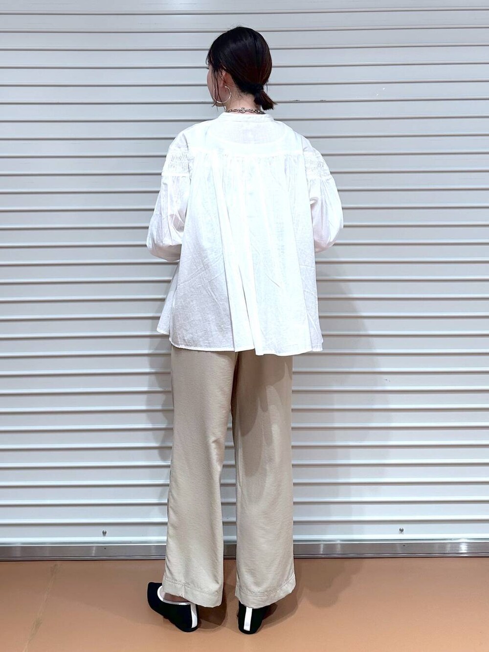 ブラック系のパンプス、ベージュ系のその他パンツ、イエロー系のハンドバッグを着用したレディースの春コーディネートの4枚目の写真