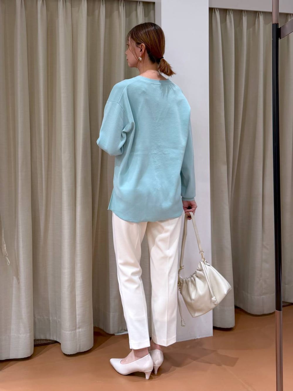 ベージュ系のパンプス、グリーン系のカーディガン/ボレロ、ホワイト系のハンドバッグを着用したレディースの冬コーディネートの4枚目の写真