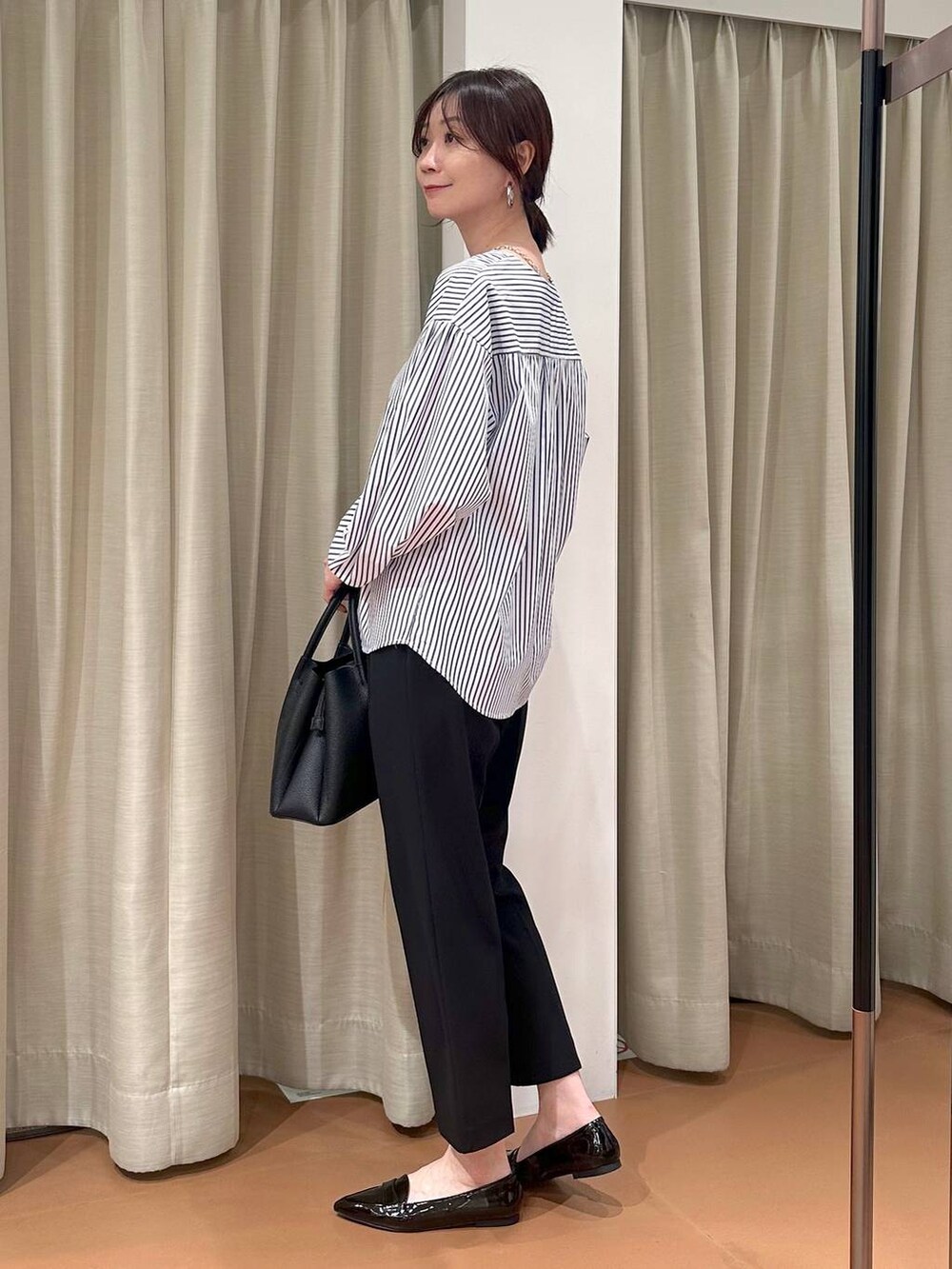ブラック系のその他パンツ、ブルー系のシャツ/ブラウス、ブラック系のハンドバッグを着用したレディースの春コーディネートの3枚目の写真