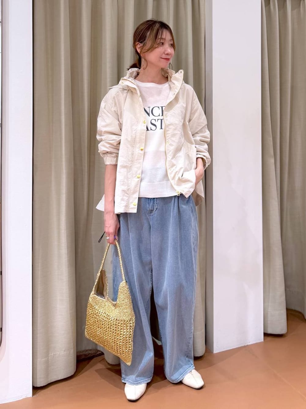 ホワイト系のパンプス、ブルー系のデニムパンツ、ホワイト系のマウンテンパーカーを着用したレディースの春コーディネートの2枚目の写真