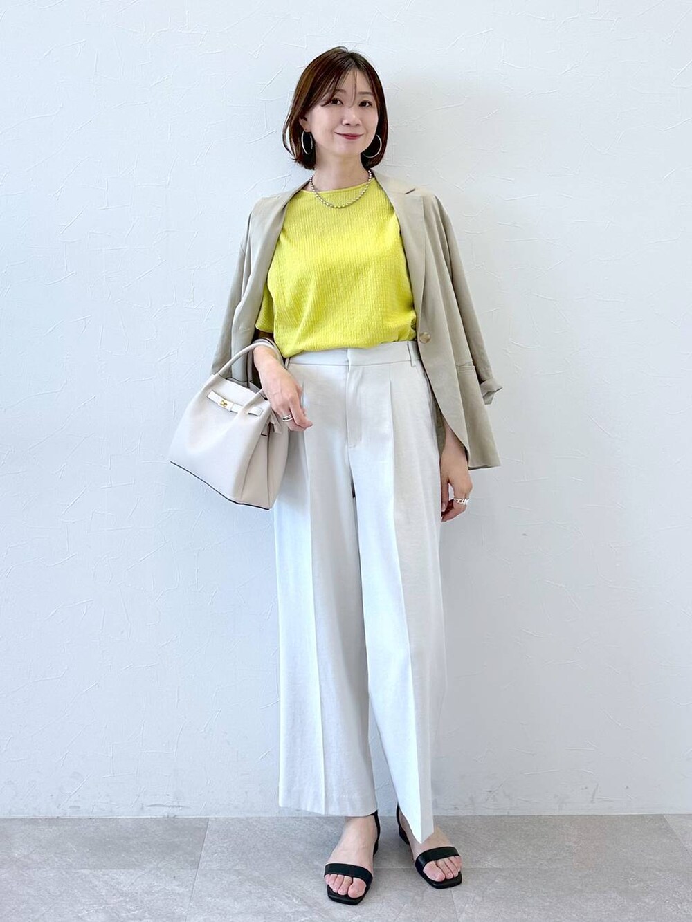 ベージュ系のその他アウター、グレー系のその他パンツ、ブラック系のサンダルを着用したレディースの夏コーディネートの2枚目の写真