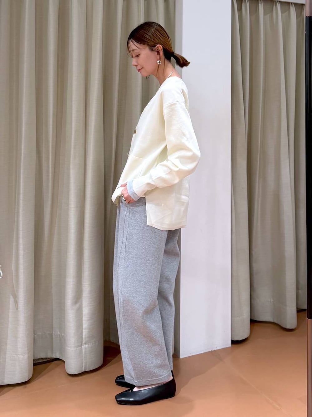 ホワイト系のカーディガン/ボレロ、ホワイト系のハンドバッグ、ブラック系のパンプスを着用したレディースの冬コーディネートの3枚目の写真