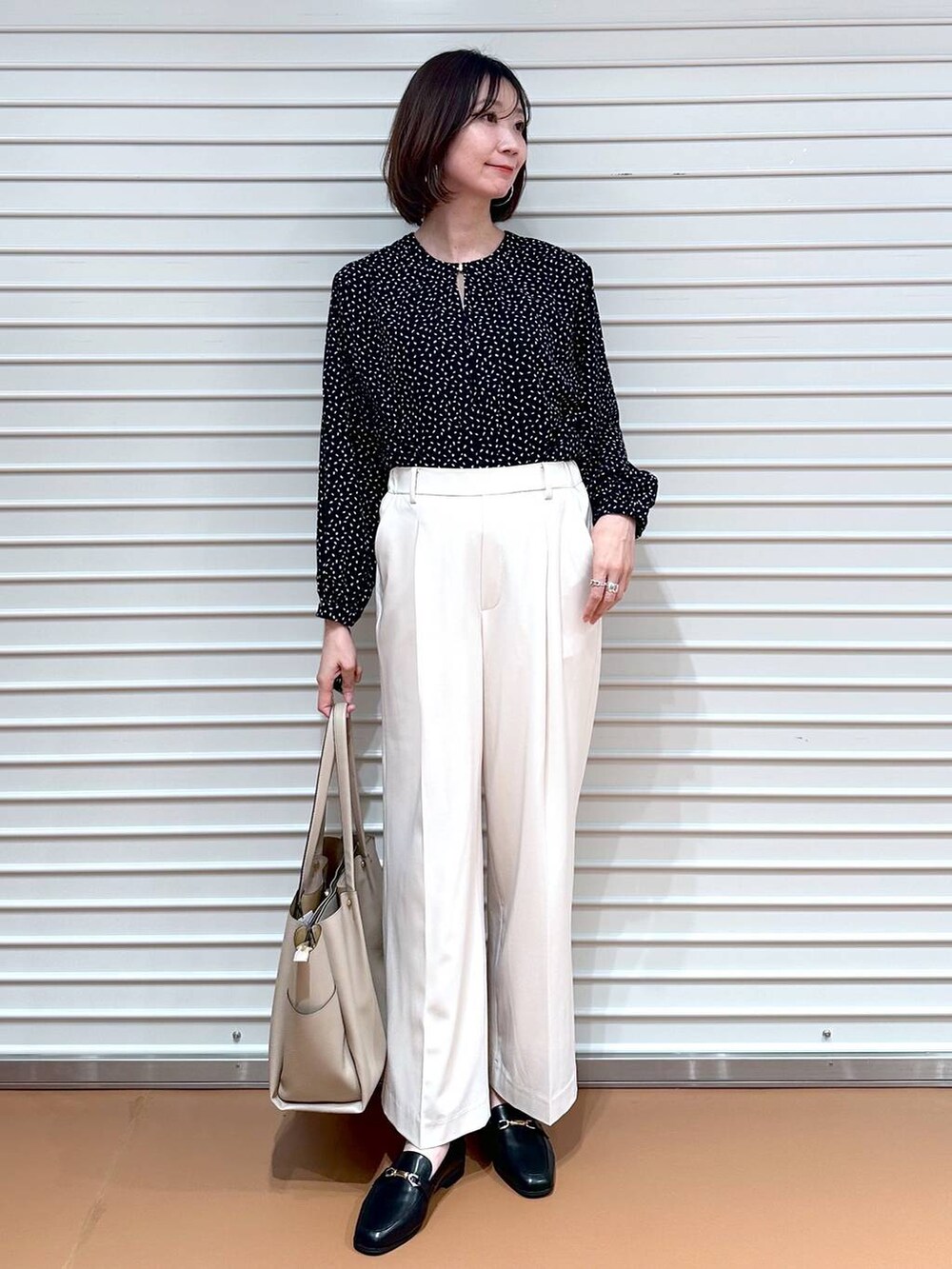 ブラック系のシャツ/ブラウス、ホワイト系のその他パンツ、ベージュ系のトートバッグを着用したレディースの春コーディネートの5枚目の写真