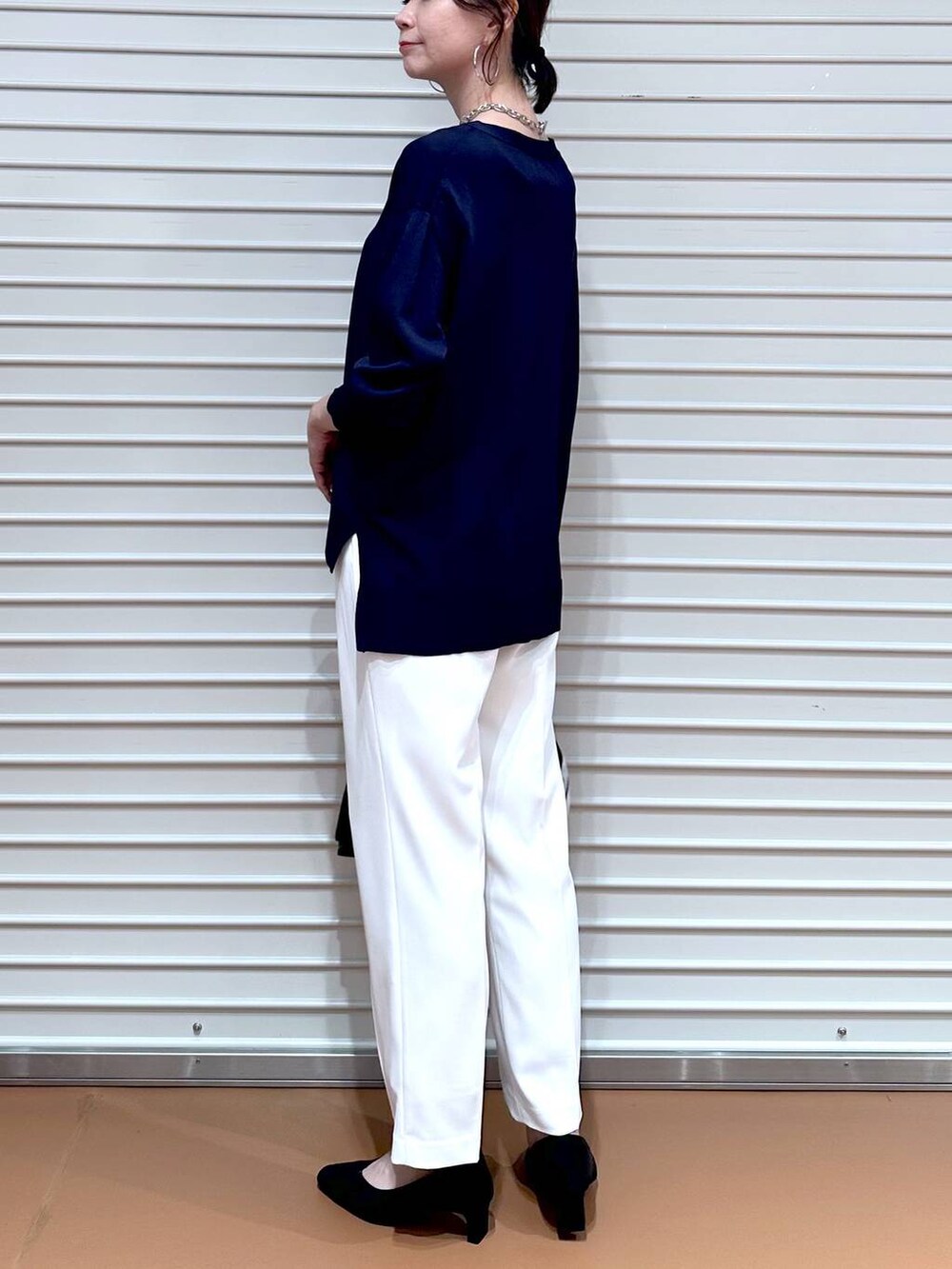 ブルー系のニット/セーター、ブラック系のショルダーバッグ、ホワイト系のその他パンツを着用したレディースの春コーディネートの7枚目の写真