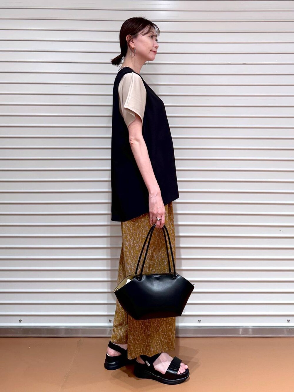 ブラック系のシャツ/ブラウス、ベージュ系のTシャツ/カットソー、ブラック系のサンダルを着用したレディースの夏コーディネートの3枚目の写真