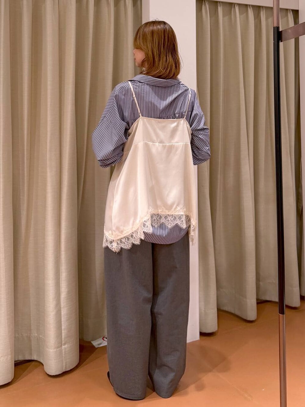 ブラック系のパンプス、ホワイト系のキャミソール、ブラック系のトートバッグを着用したレディースの春コーディネートの4枚目の写真