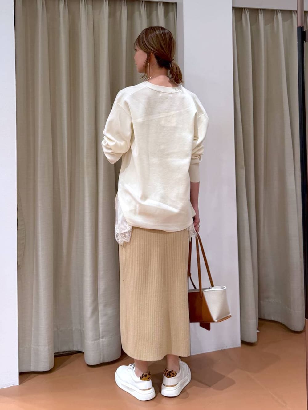 ホワイト系のカーディガン/ボレロ、ベージュ系のスカート、ホワイト系のキャミソールを着用したレディースの冬コーディネートの5枚目の写真