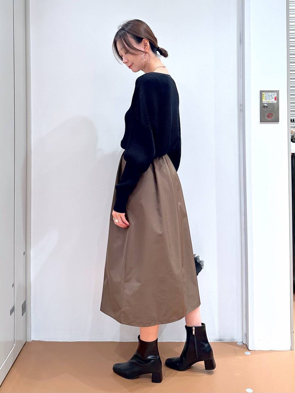 ブラック系のカーディガン/ボレロ、ブラウン系のスカート、ブラック系のブーツを着用したレディースの秋コーディネートの3枚目の写真