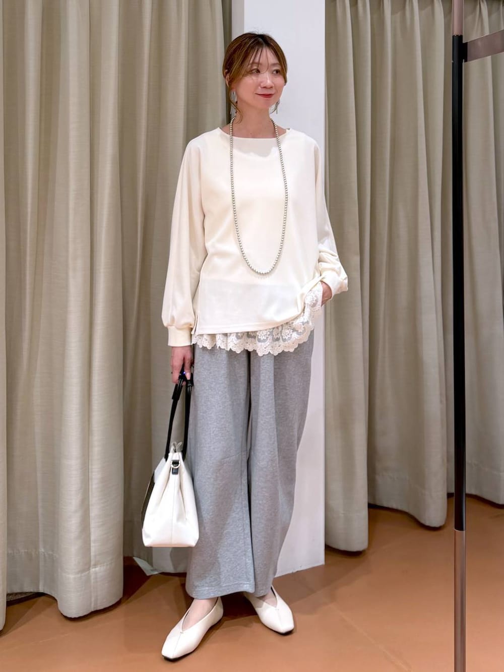 ホワイト系のパンプス、ホワイト系のタンクトップ、グレー系のスウェットパンツを着用したレディースの春コーディネートの2枚目の写真