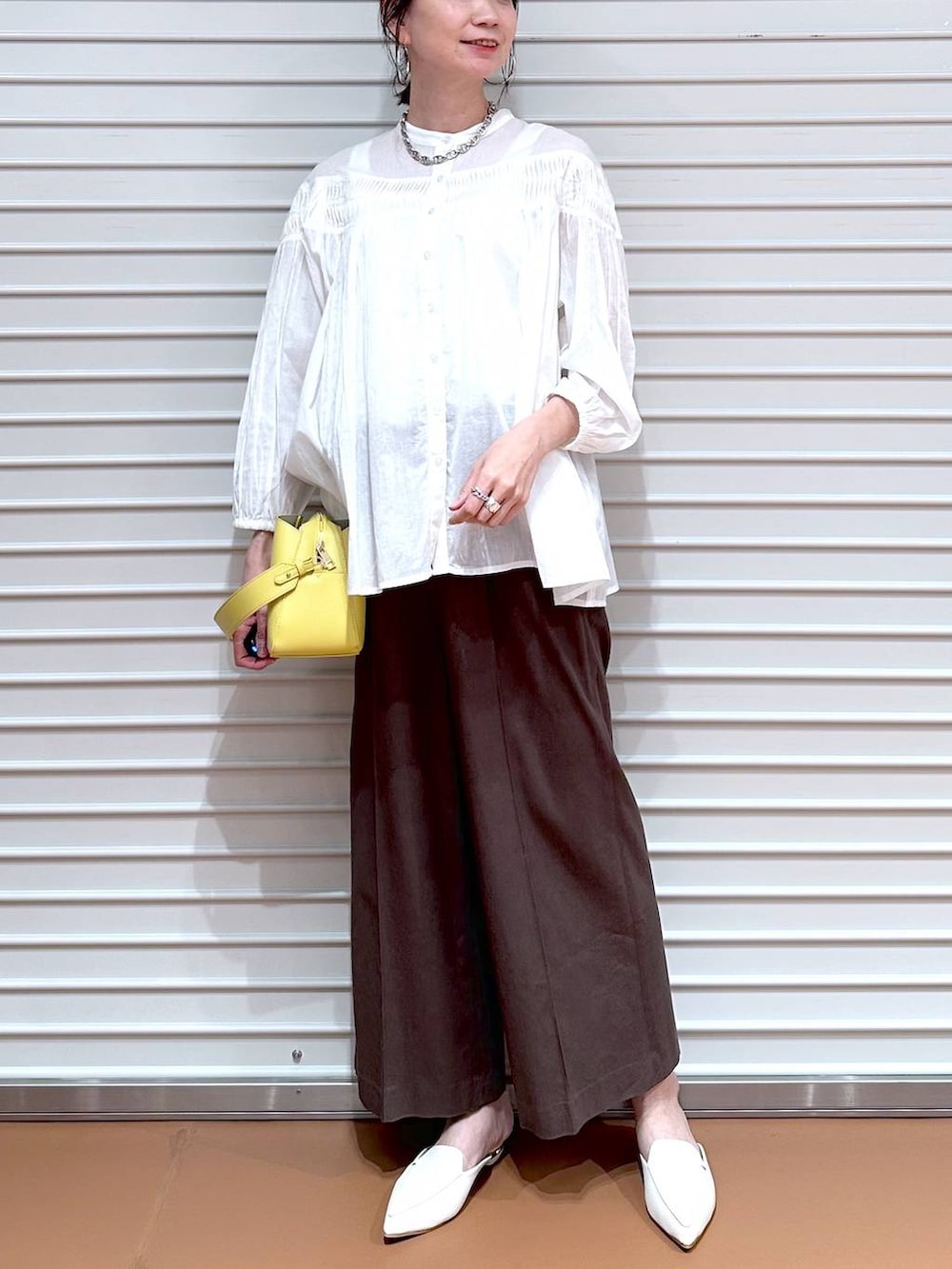 ブラウン系のその他パンツ、ブラウン系のその他パンツ、イエロー系のハンドバッグを着用したレディースの夏コーディネートの5枚目の写真