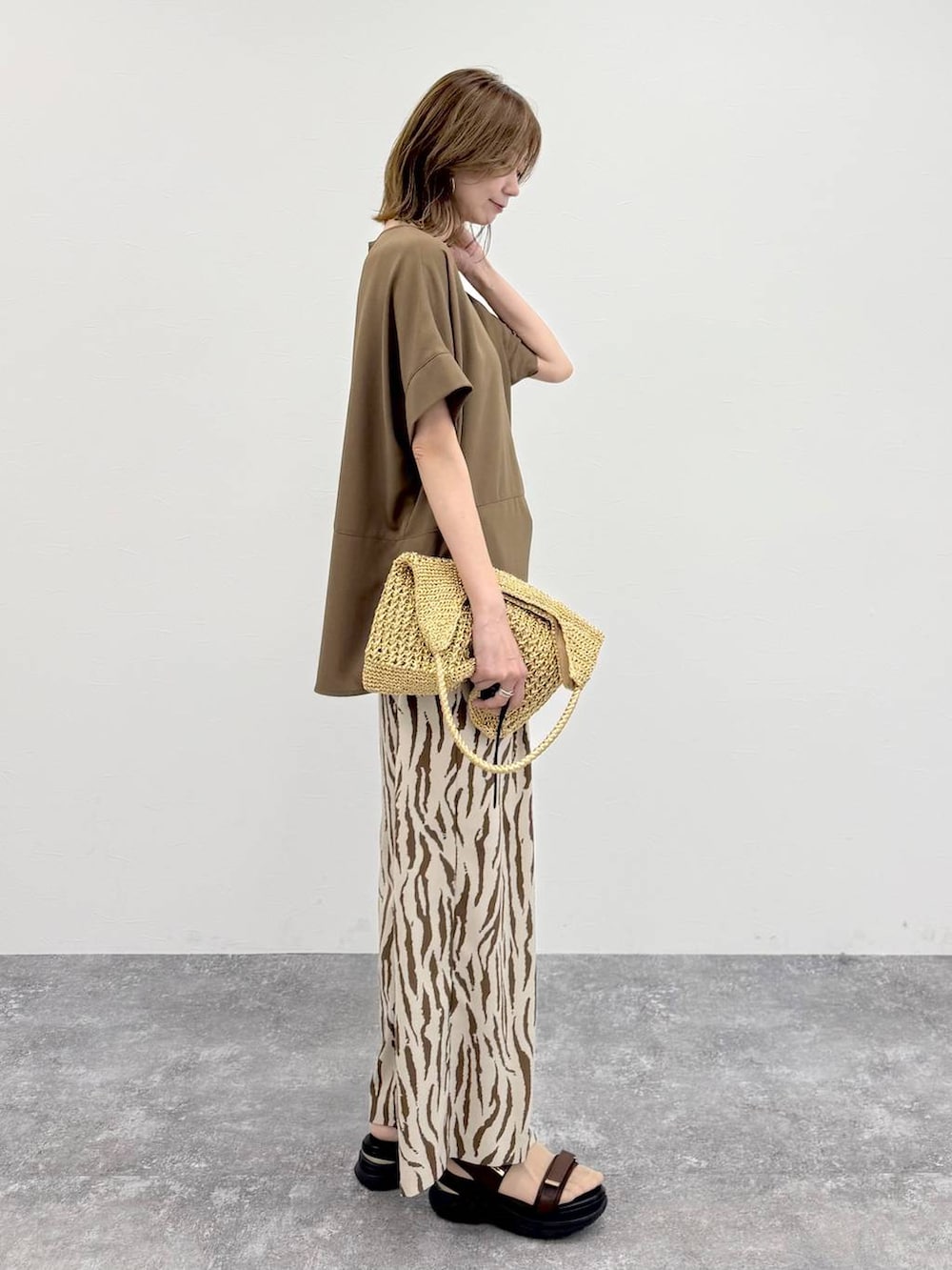 ゴールド系のトートバッグ、その他のその他パンツ、ブラウン系のTシャツ/カットソーを着用したレディースの春コーディネートの5枚目の写真