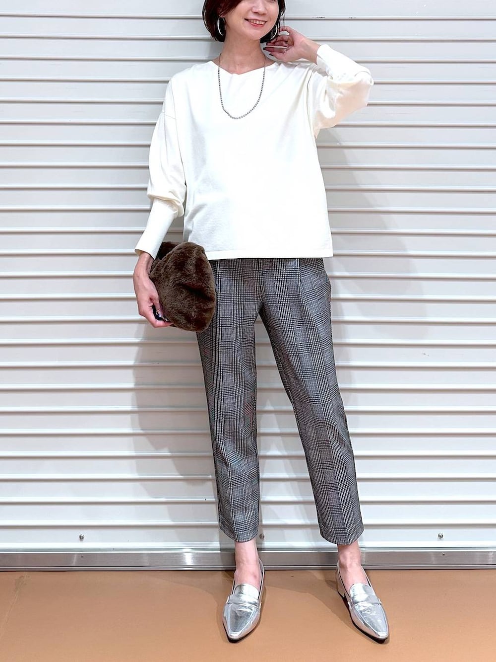 ブラック系のその他パンツ、シルバー系のローファー、シルバー系のネックレスを着用したレディースの秋コーディネートの5枚目の写真