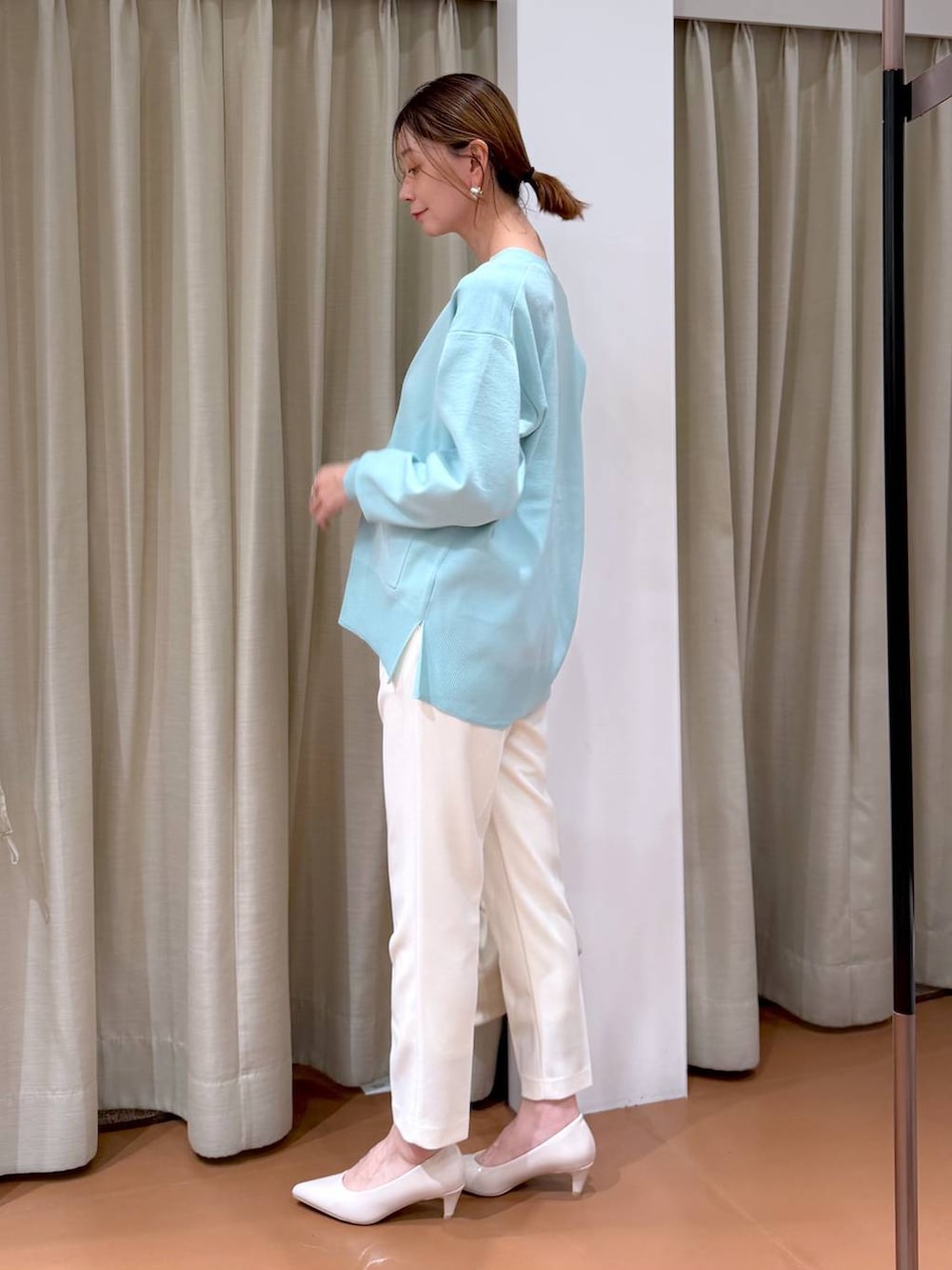 ベージュ系のパンプス、グリーン系のカーディガン/ボレロ、ホワイト系のハンドバッグを着用したレディースの冬コーディネートの3枚目の写真