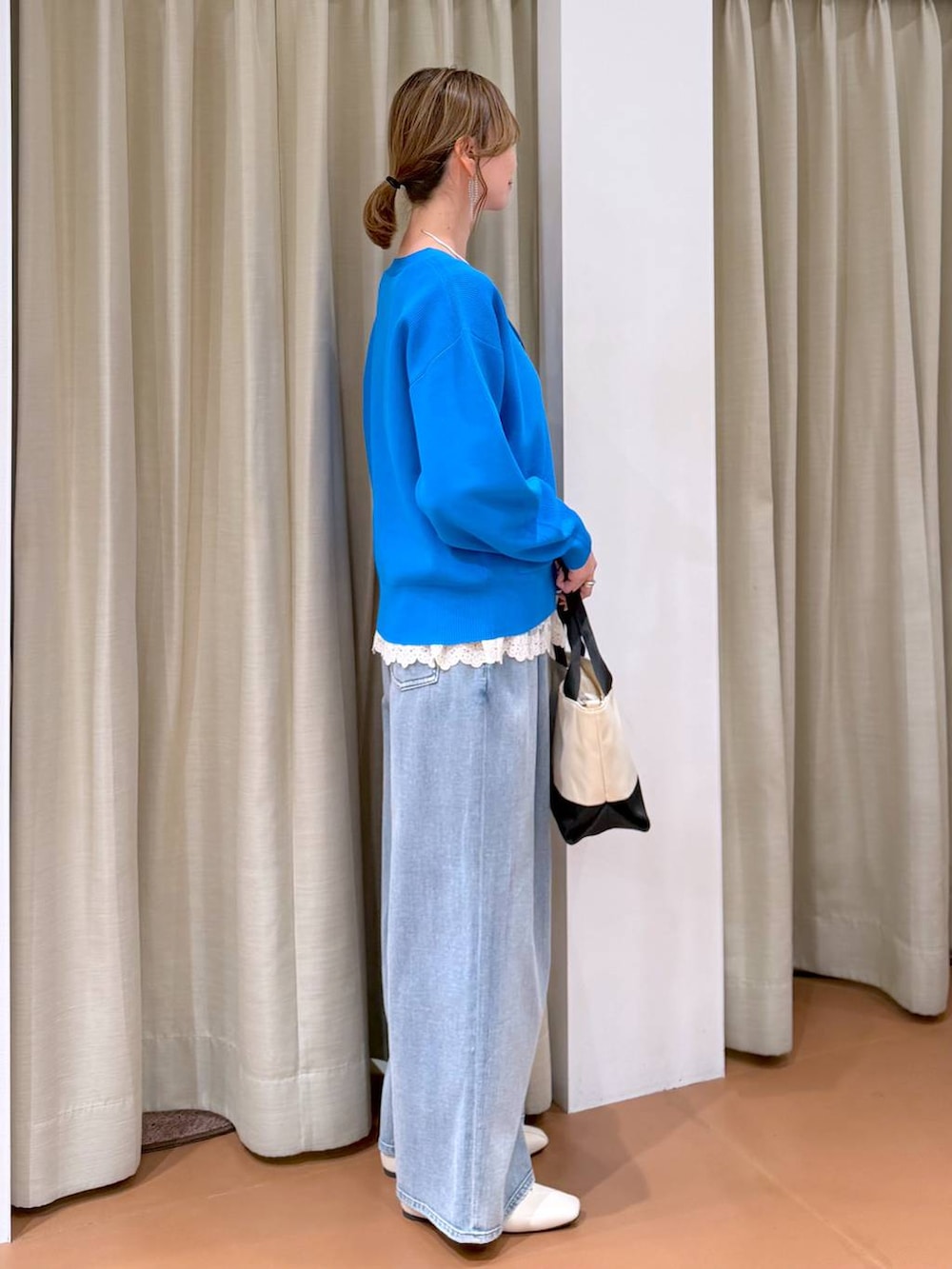 ホワイト系のパンプス、ホワイト系のタンクトップ、ブルー系のデニムパンツを着用したレディースの春コーディネートの5枚目の写真