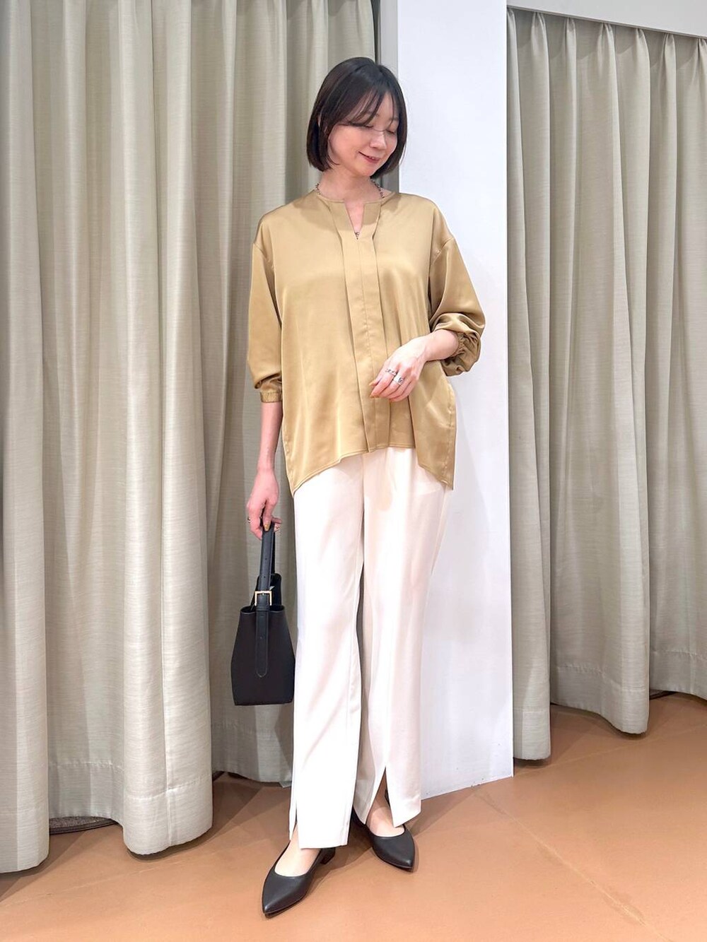 ホワイト系のその他パンツ、ブラウン系のシャツ/ブラウス、ブラック系のハンドバッグを着用したレディースの春コーディネートの2枚目の写真