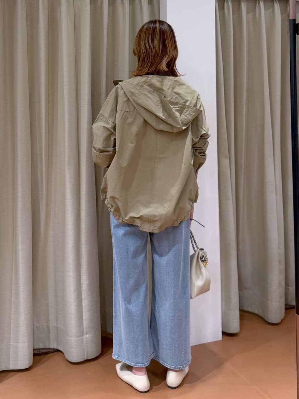 ホワイト系のパンプス、ブルー系のデニムパンツ、ホワイト系のハンドバッグを着用したレディースの春コーディネートの4枚目の写真