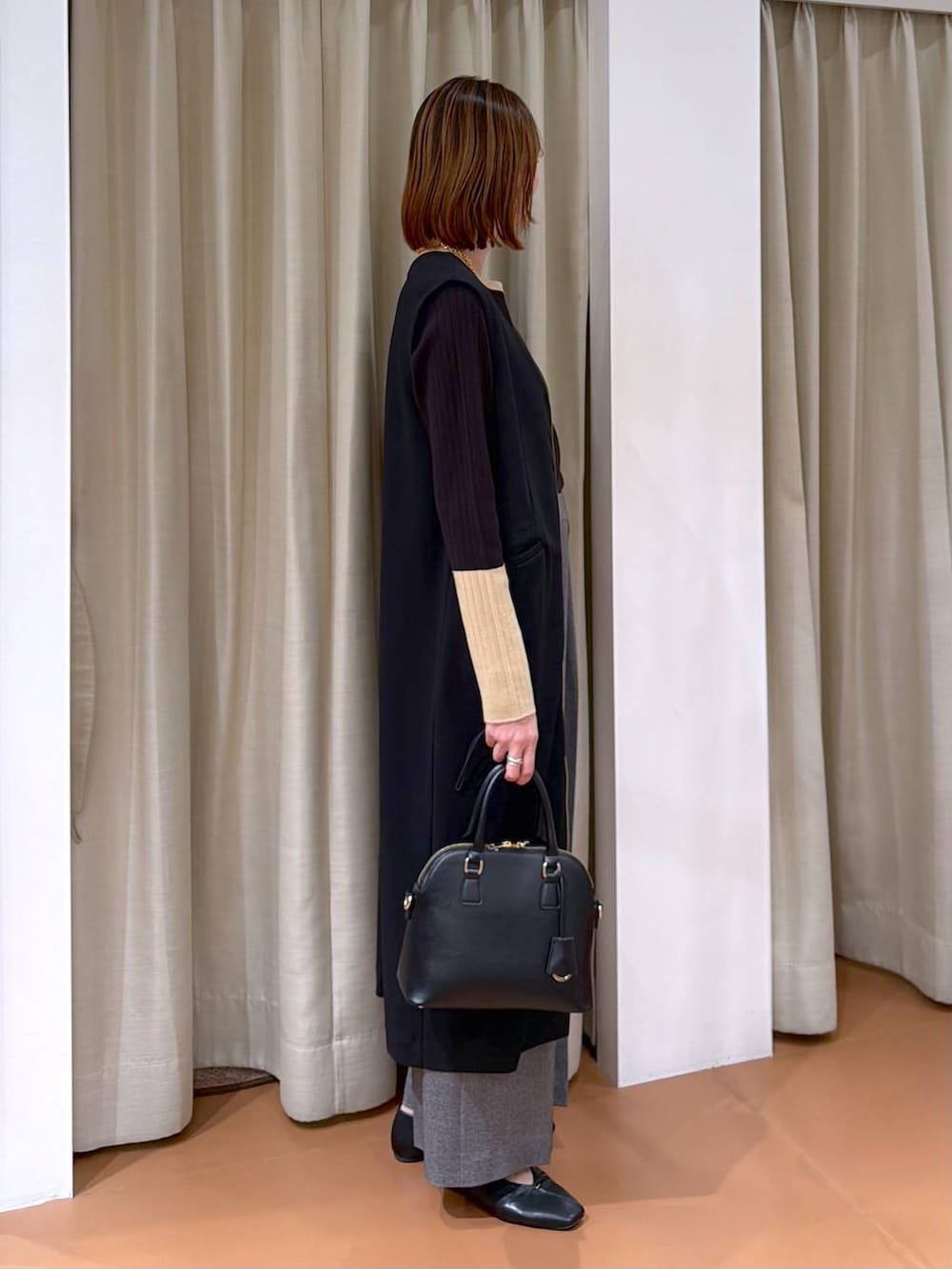 ブラック系のハンドバッグ、グレー系のその他パンツ、ブラック系のパンプスを着用したレディースの冬コーディネートの5枚目の写真