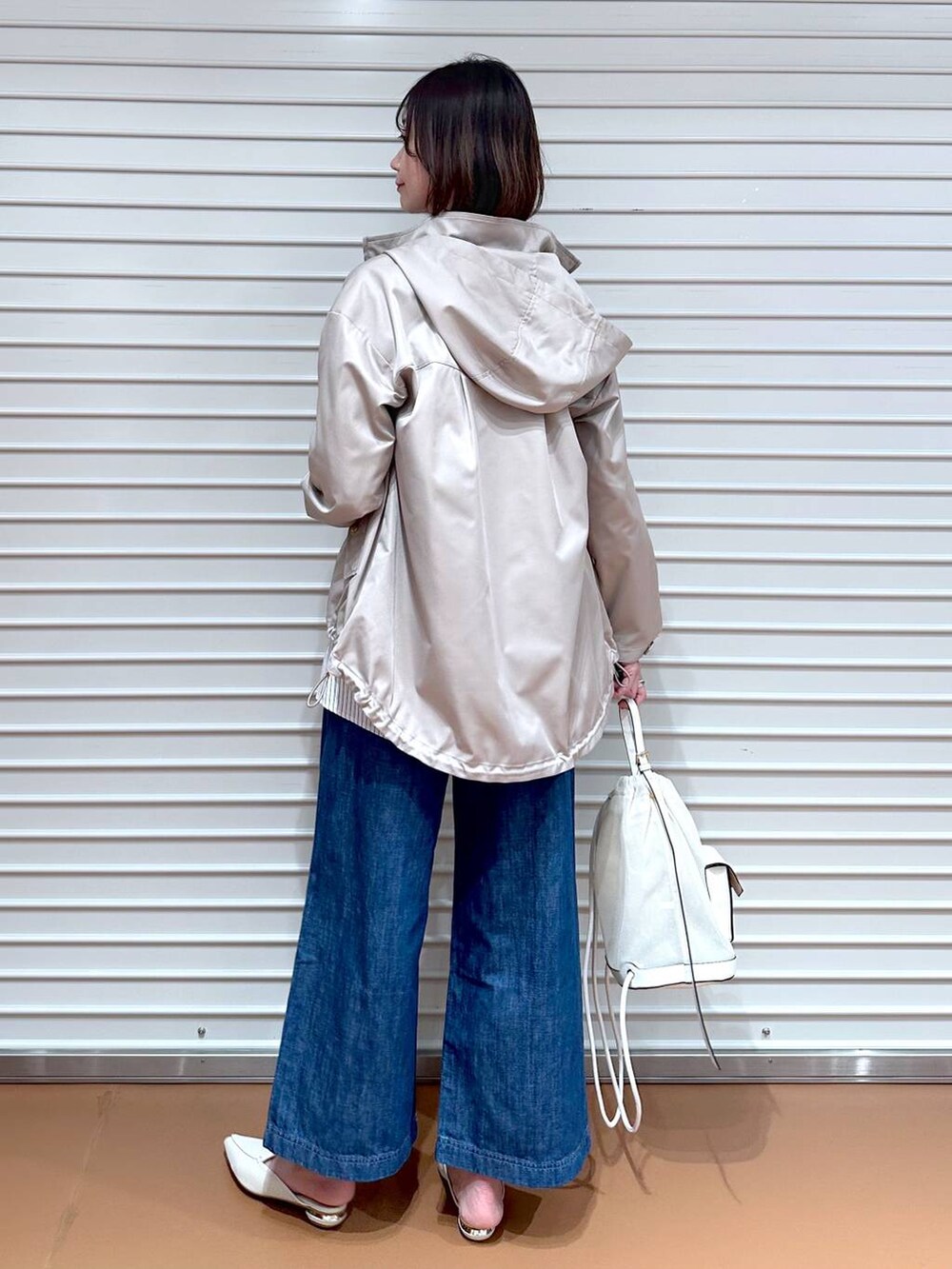 ブルー系のデニムパンツ、ホワイト系のシャツ/ブラウス、ベージュ系のマウンテンパーカーを着用したレディースの春コーディネートの3枚目の写真