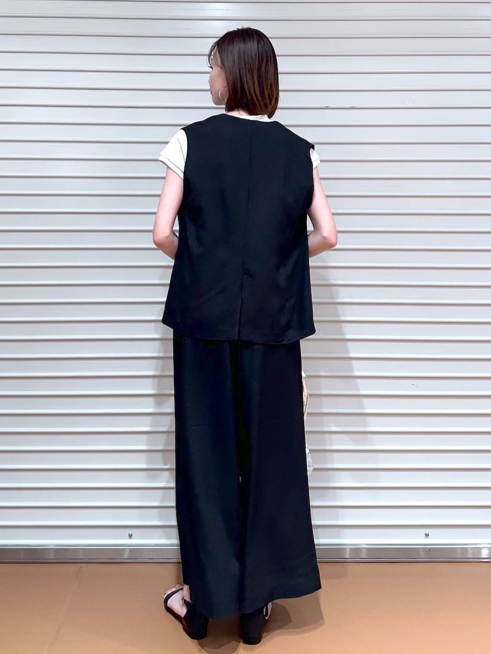 ブラック系のベスト、ホワイト系のTシャツ/カットソー、ブラック系のその他パンツを着用したレディースの夏コーディネートの4枚目の写真