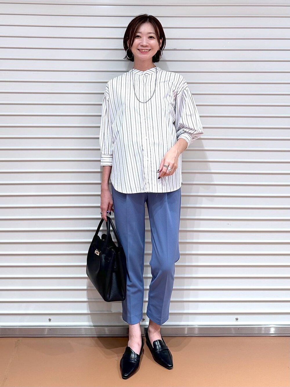 ブルー系のその他パンツ、ブラック系のハンドバッグ、ブラック系のローファーを着用したレディースの秋コーディネートの2枚目の写真