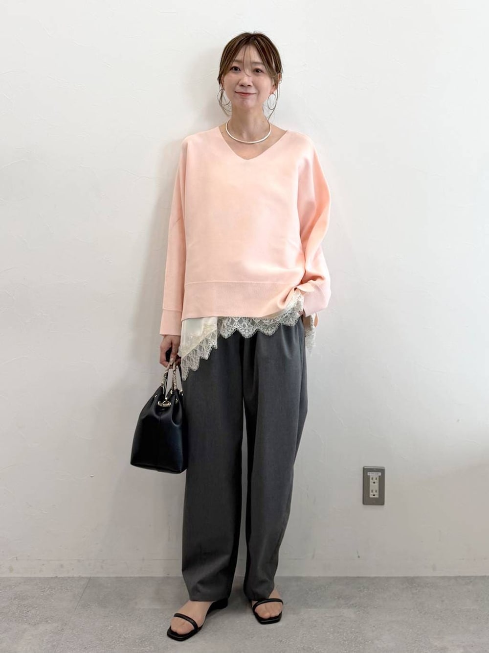 ホワイト系のキャミソール、グレー系のその他パンツ、ブラック系のハンドバッグを着用したレディースの春コーディネートの2枚目の写真