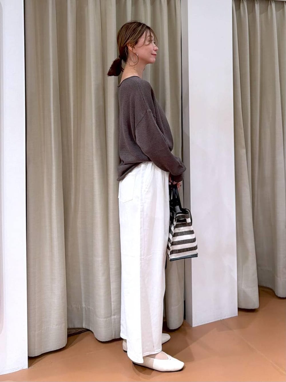 ホワイト系のパンプス、ホワイト系のデニムパンツ、ブラック系のトートバッグを着用したレディースの春コーディネートの5枚目の写真