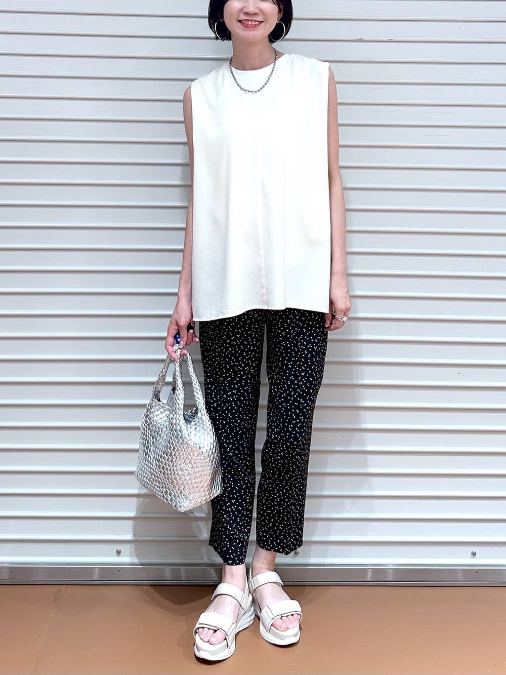 ホワイト系のシャツ/ブラウス、シルバー系のトートバッグ、ホワイト系のサンダルを着用したレディースの夏コーディネートの5枚目の写真