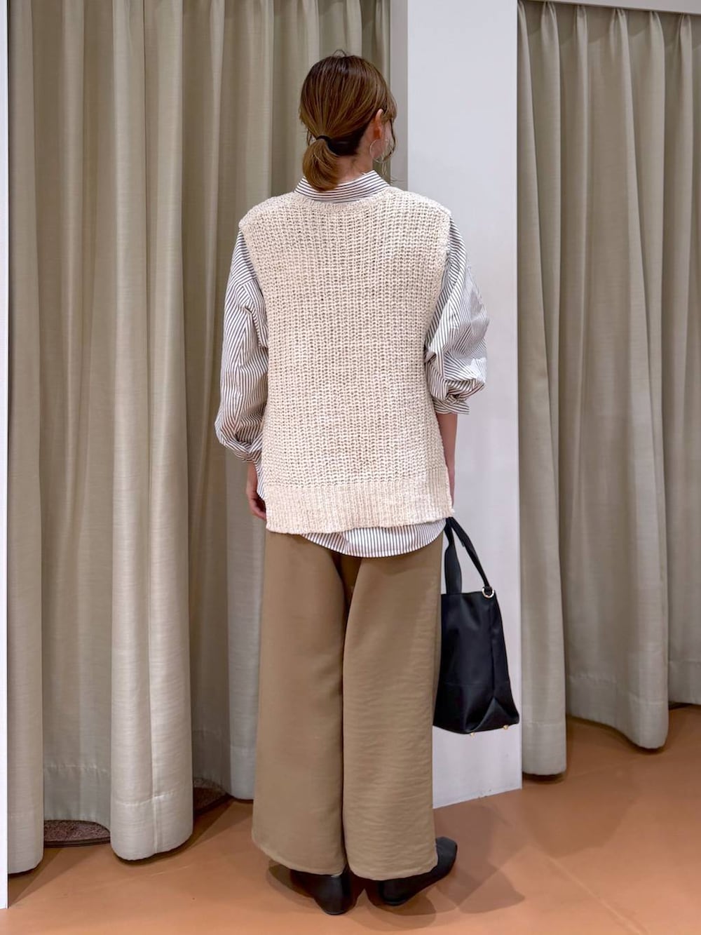 ブラック系のトートバッグ、ブラック系のパンプス、ブラウン系のシャツ/ブラウスを着用したレディースの春コーディネートの4枚目の写真