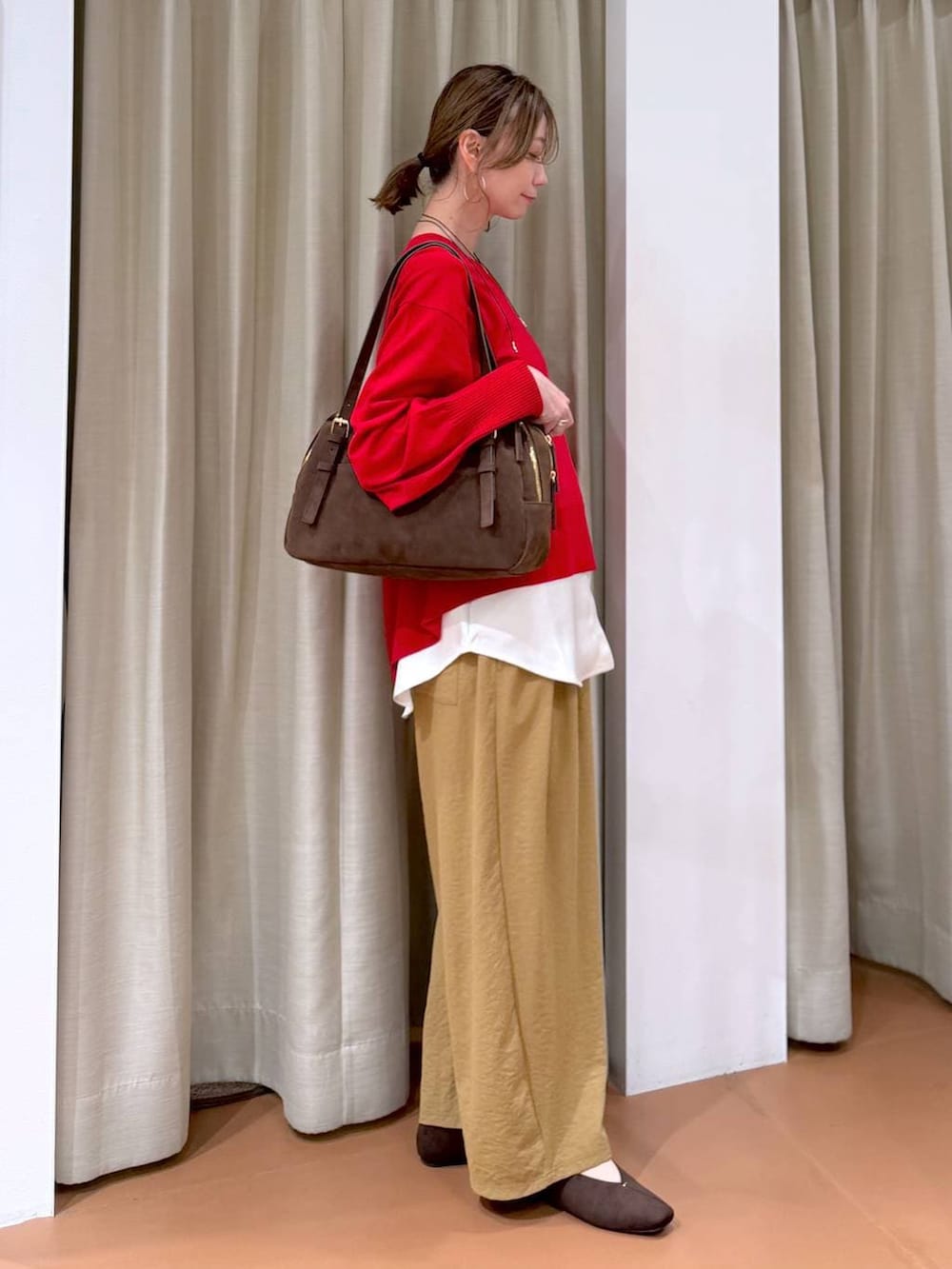 ブラウン系のパンプス、ブラウン系のボストンバッグ、イエロー系のその他パンツを着用したレディースの春コーディネートの3枚目の写真