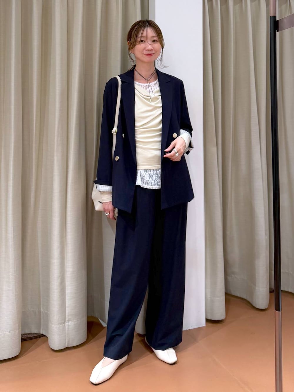 ホワイト系のハンドバッグ、ホワイト系のパンプス、ブルー系のその他パンツを着用したレディースの春コーディネートの6枚目の写真