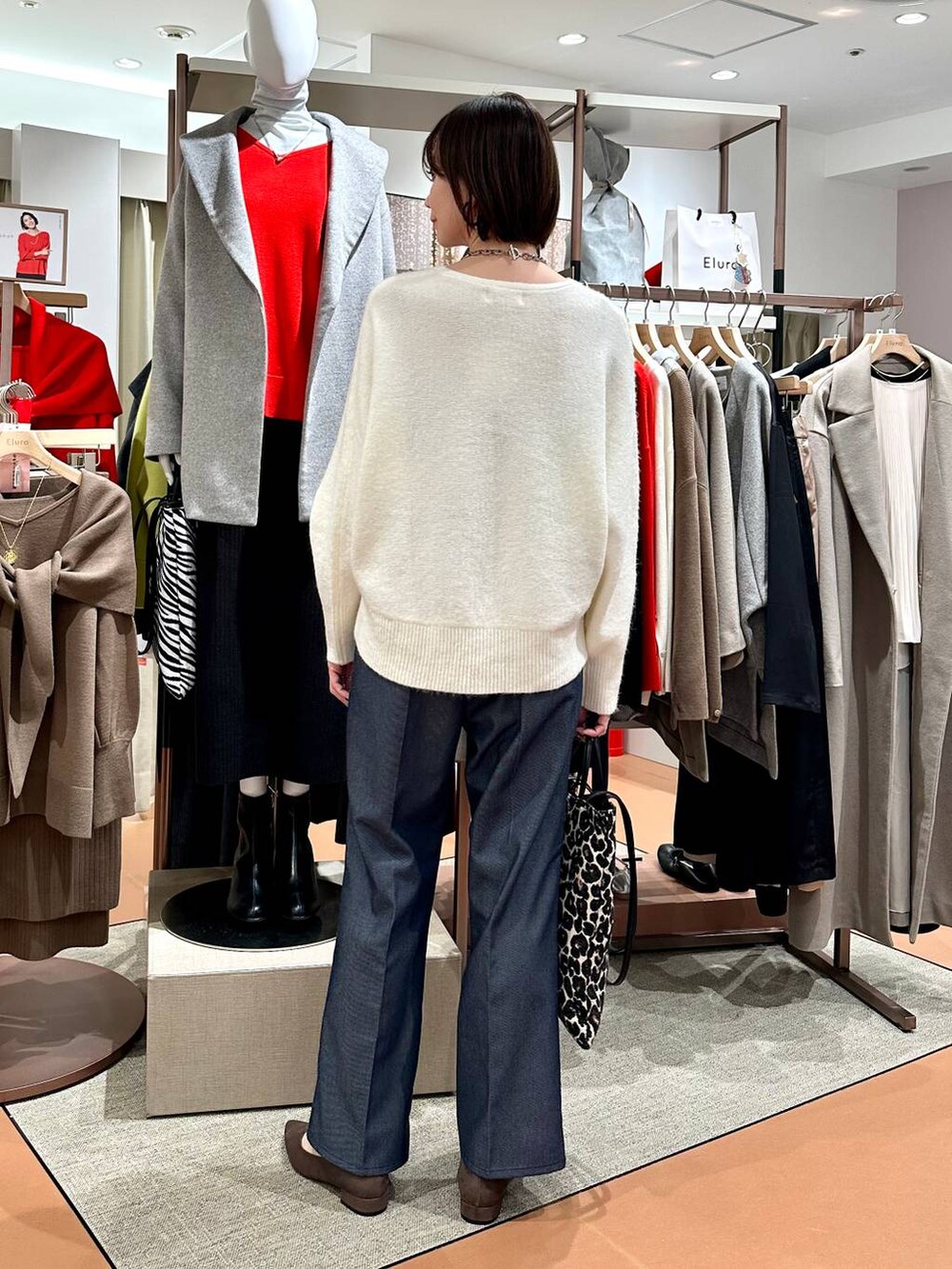 ブルー系のデニムパンツ、ホワイト系のニット/セーター、ブラウン系のパンプスを着用したレディースの冬コーディネートの4枚目の写真