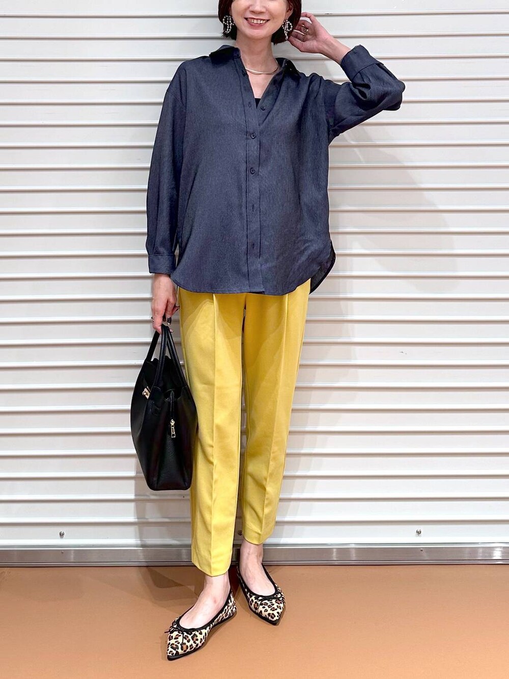 イエロー系のその他パンツ、ブラック系のハンドバッグ、ブラウン系のパンプスを着用したレディースの夏コーディネートの5枚目の写真