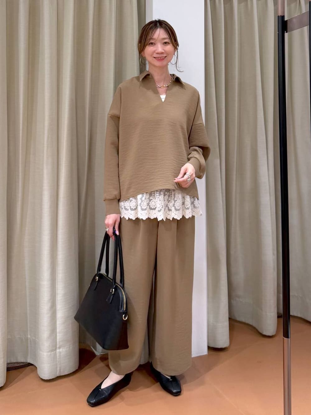 ブラック系のパンプス、ホワイト系のタンクトップ、ブラック系のハンドバッグを着用したレディースの春コーディネートの2枚目の写真