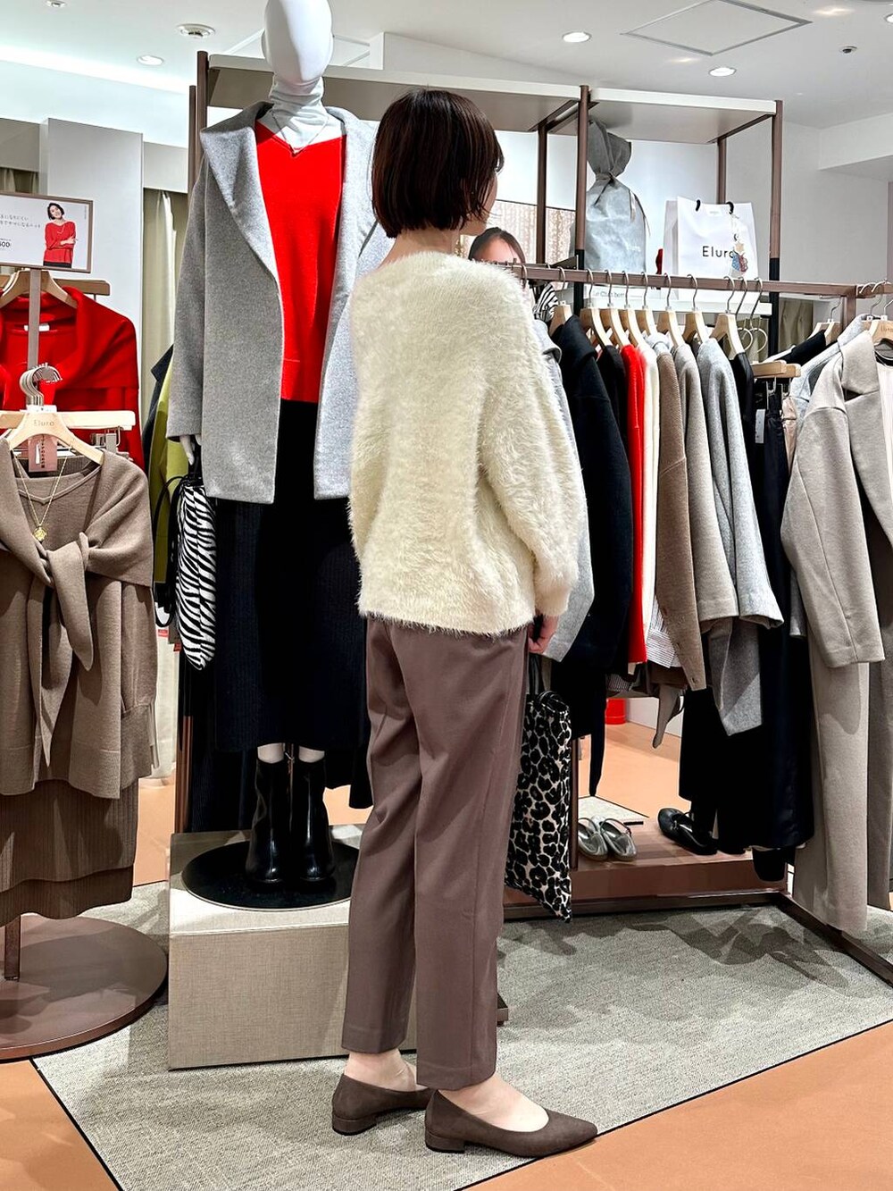 ブラウン系のその他パンツ、ブラウン系のパンプス、ホワイト系のニット/セーターを着用したレディースの冬コーディネートの5枚目の写真