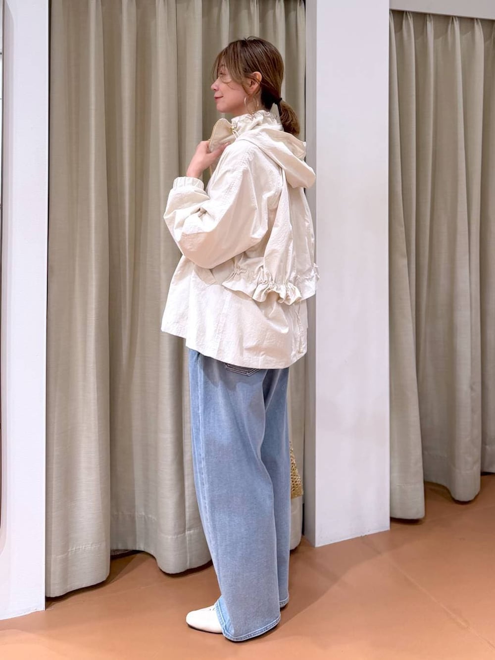 ホワイト系のパンプス、ブルー系のデニムパンツ、ホワイト系のマウンテンパーカーを着用したレディースの春コーディネートの3枚目の写真