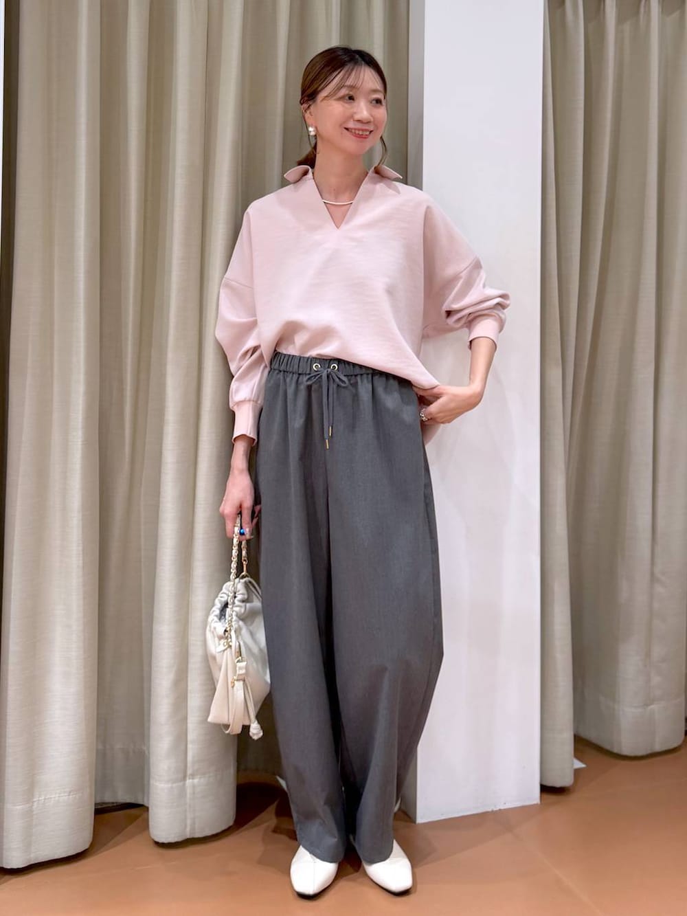 ホワイト系のハンドバッグ、ホワイト系のパンプス、グレー系のその他パンツを着用したレディースの冬コーディネートの2枚目の写真