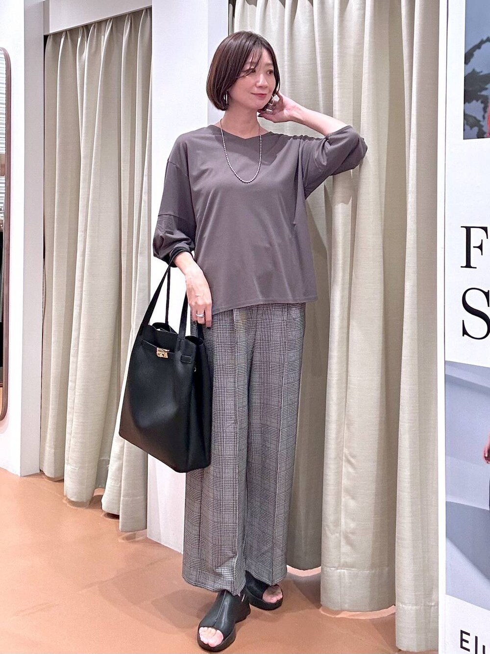 ブラック系のサンダル、ブラック系のその他パンツ、ブラック系のトートバッグを着用したレディースの秋コーディネートの2枚目の写真