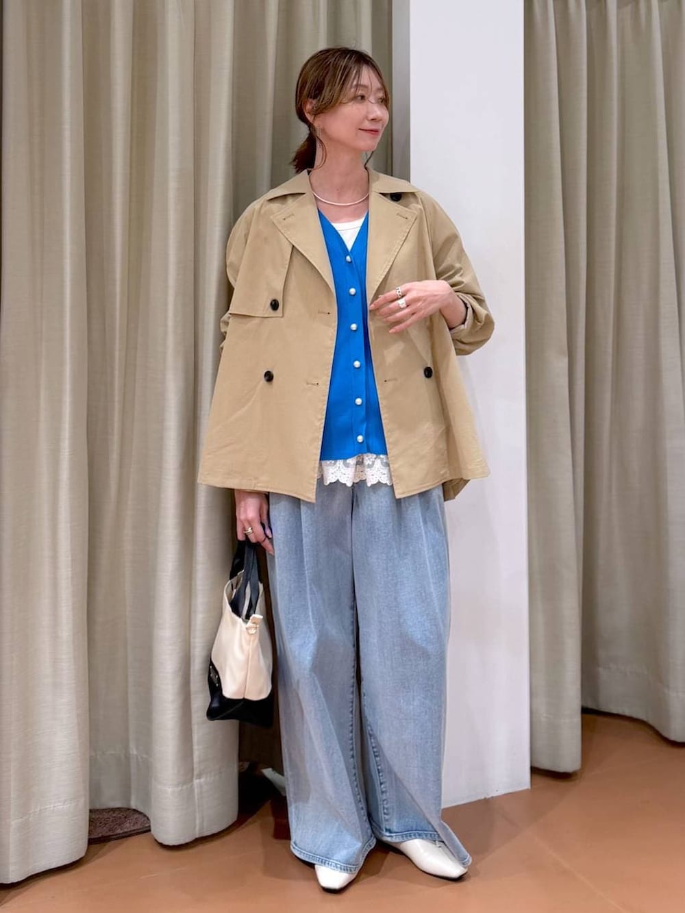 ホワイト系のパンプス、ホワイト系のタンクトップ、ブルー系のデニムパンツを着用したレディースの春コーディネートの6枚目の写真