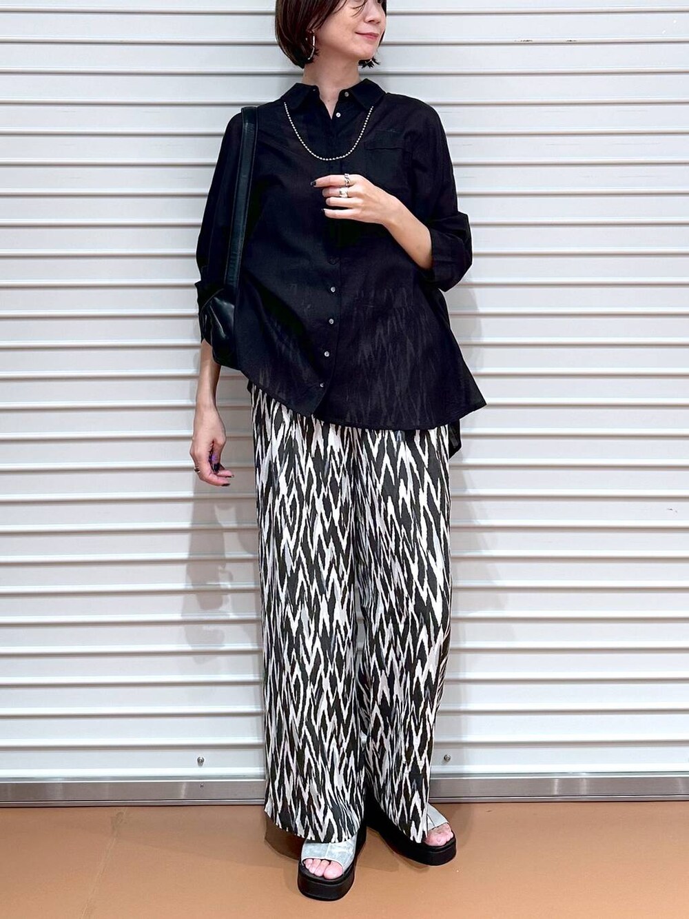 ブラック系のシャツ/ブラウス、シルバー系のサンダル、ブラック系のその他パンツを着用したレディースの夏コーディネートの5枚目の写真