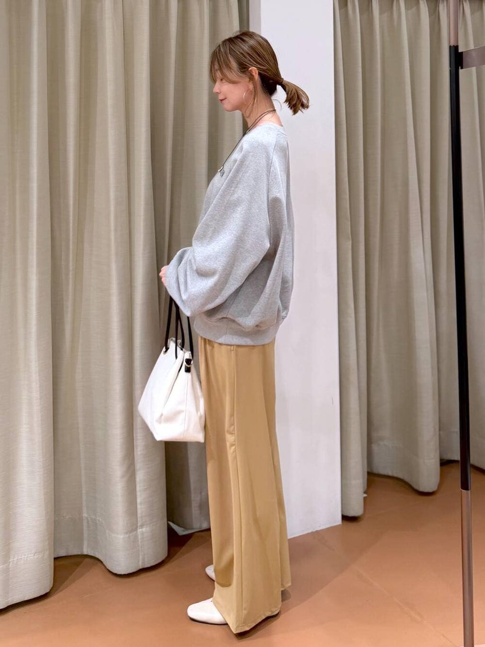 ホワイト系のパンプス、ホワイト系のトートバッグ、グレー系のスウェットを着用したレディースの春コーディネートの3枚目の写真