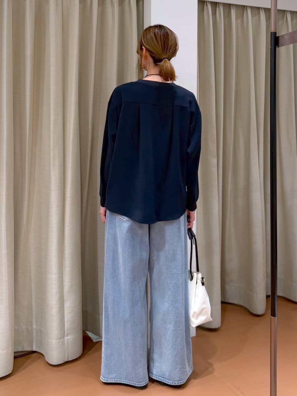 ホワイト系のパンプス、ブルー系のデニムパンツ、ホワイト系のトートバッグを着用したレディースの春コーディネートの4枚目の写真