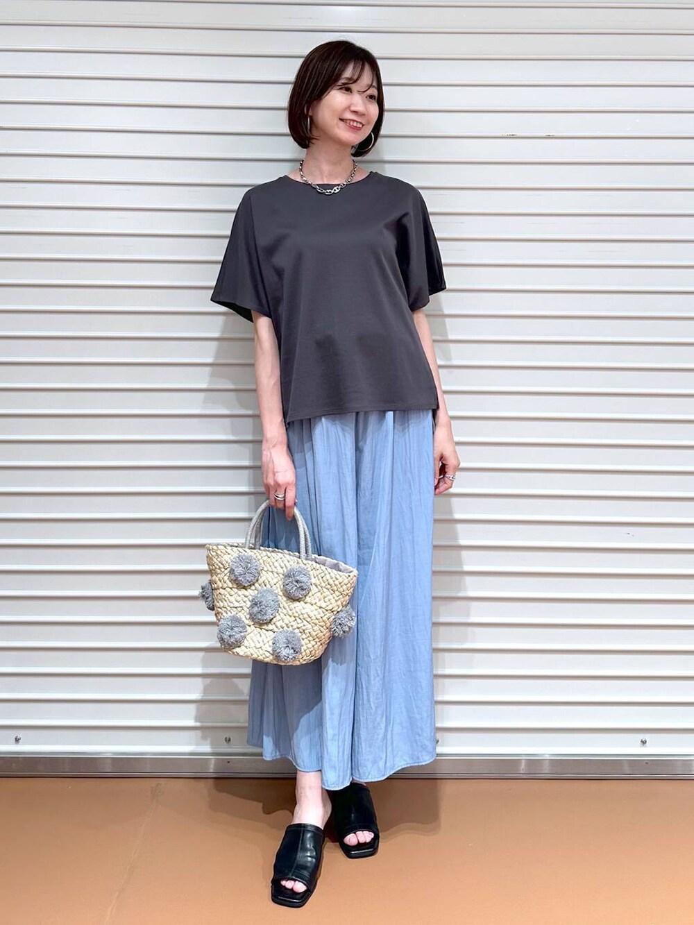 グレー系のTシャツ/カットソー、ブラック系のサンダル、ブルー系のその他パンツを着用したレディースの夏コーディネートの2枚目の写真