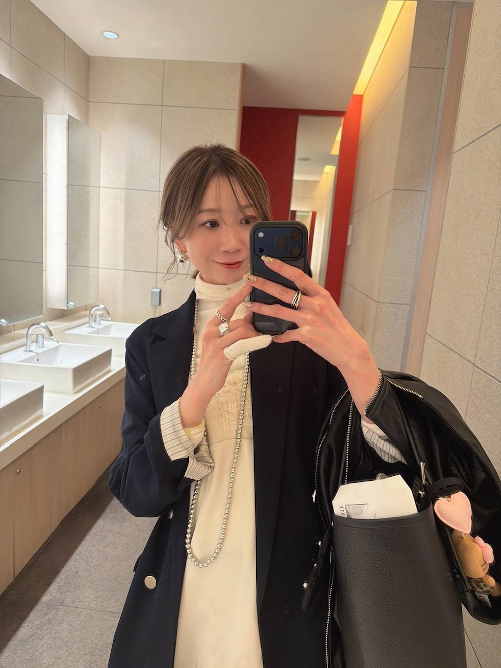 ホワイト系のTシャツ/カットソー、ホワイト系のパンプス、ブルー系のデニムパンツを着用したレディースの冬コーディネートの4枚目の写真