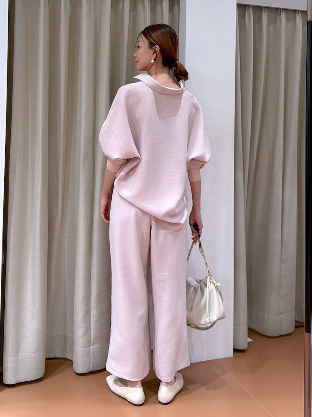 ホワイト系のハンドバッグ、ホワイト系のパンプス、ピンク系のその他パンツを着用したレディースの冬コーディネートの4枚目の写真