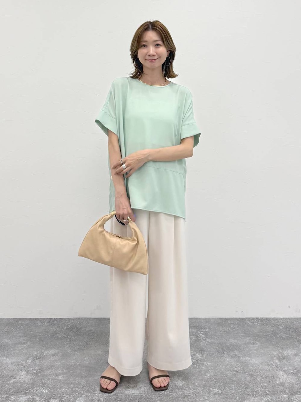 ホワイト系のその他パンツ、グリーン系のTシャツ/カットソー、ゴールド系のネックレスを着用したレディースの春コーディネートの2枚目の写真