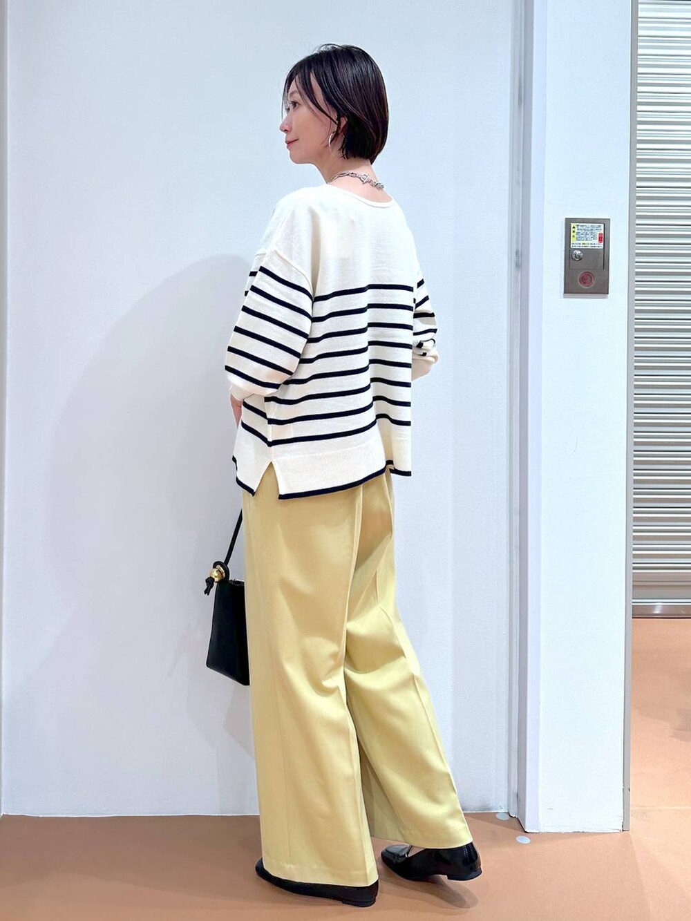 イエロー系のその他パンツ、ブルー系のニット/セーター、ブラック系のパンプスを着用したレディースの冬コーディネートの3枚目の写真