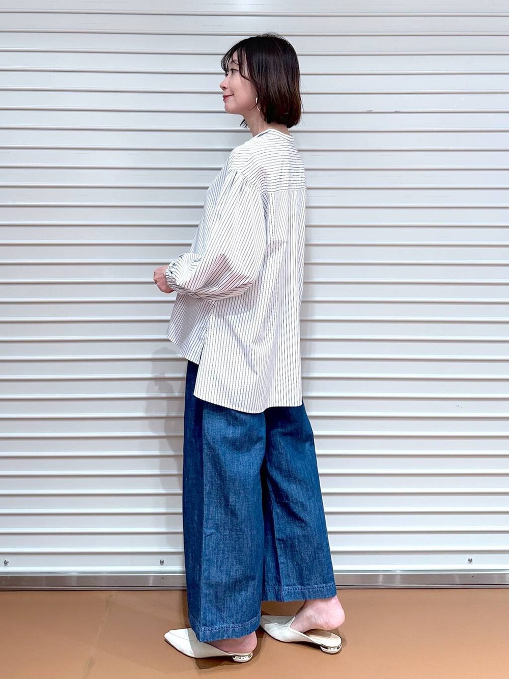 ブルー系のデニムパンツ、ホワイト系のシャツ/ブラウス、ベージュ系のマウンテンパーカーを着用したレディースの春コーディネートの5枚目の写真