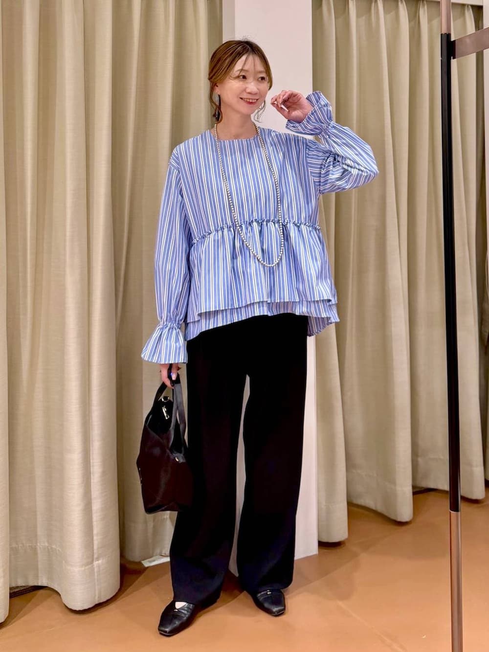 ブラック系のその他パンツ、ブラック系のパンプス、ブルー系のシャツ/ブラウスを着用したレディースの春コーディネートの7枚目の写真