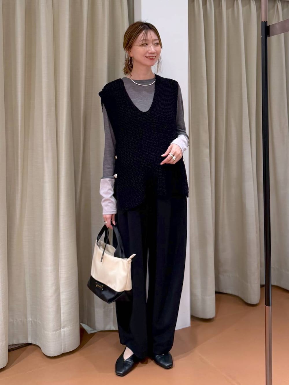 ブラック系のパンプス、ブラック系のその他パンツ、ブラック系のベストを着用したレディースの春コーディネートの2枚目の写真