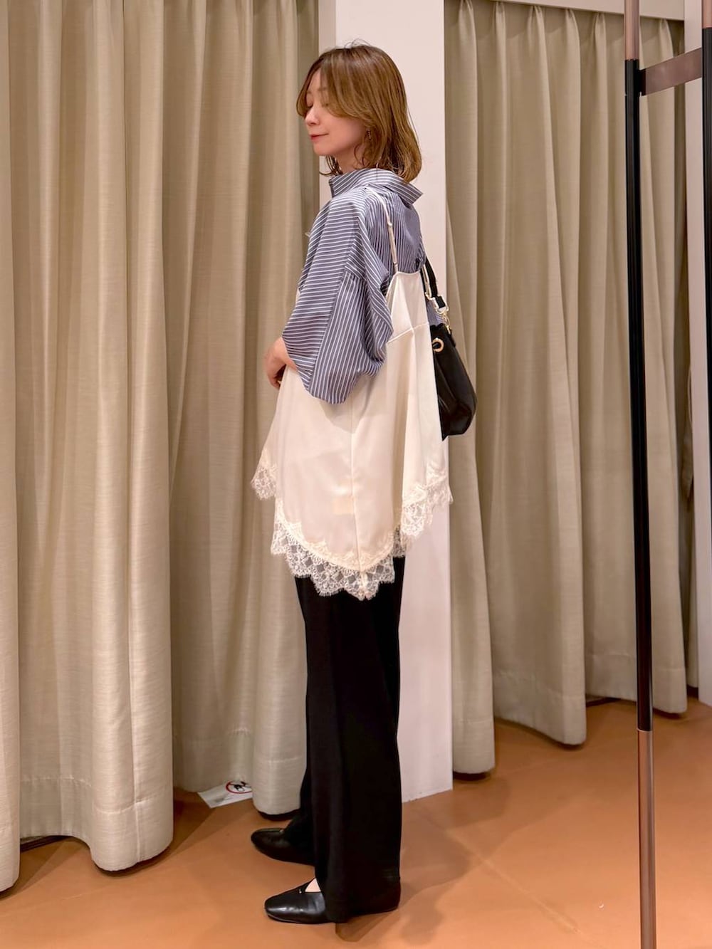 ブラック系のその他パンツ、ブラック系のパンプス、ホワイト系のキャミソールを着用したレディースの春コーディネートの3枚目の写真